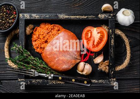 Mallorcan Sobrassada salumi di carne di maiale in un vassoio di legno sfondo di legno nero. Vista dall'alto Foto Stock