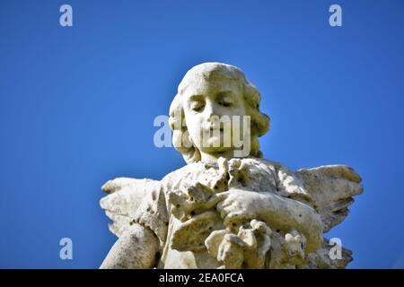 Statue di angeli in un cimitero pubblico cattolico californiano con cielo aperto che è chiaro, da sepolture pre-guerra mondiale 2 per le famiglie locali e copia Foto Stock