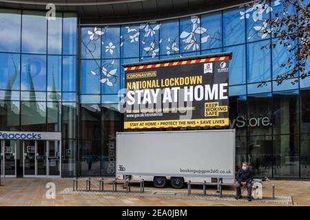 Cartello illuminato con messaggi di blocco COVID-19 in Jubilee Square, nel centro di Woking, Surrey, nel sud-est dell'Inghilterra Foto Stock