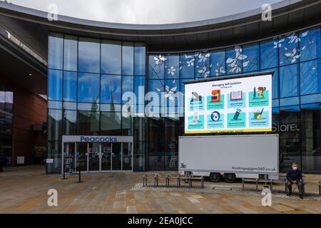 Cartello illuminato con messaggi di blocco COVID-19 per la gestione dell'autoisolamento in Jubilee Square, nel centro di Woking, nel Surrey, nel sud-est dell'Inghilterra Foto Stock