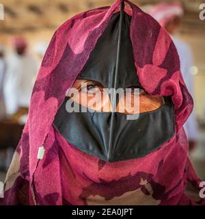 Medio Oriente, Penisola arabica, Oman, al Batinah Sud, Sinaw. 24 ottobre 2019. Donna Omani che indossa un hijab tradizionale e maschera in Sinaw. Foto Stock