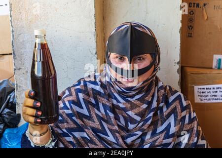 Medio Oriente, Penisola arabica, Oman, al Batinah Sud, Sinaw. 24 ottobre 2019. Donna Omani in una battaglia che vende succo al souk di Sinaw. Foto Stock