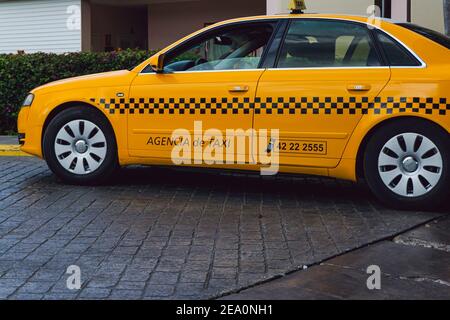 Cuba, 2016 febbraio - Vista ravvicinata di un taxi auto giallo fare Audi parcheggiato di fronte ad un hotel resort Foto Stock