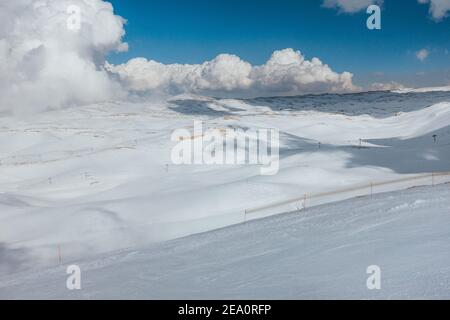 Le nuvole rotolano sopra le colline ondulate e le pendici del Mzaar Kfardebian Ski Resort in Libano Foto Stock