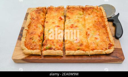 Le fette di pizza si avvicinano su una tavola di legno. Pizza vegetariana passo per passo ricetta Foto Stock