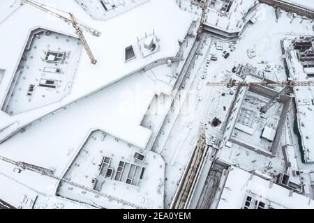 vista dall'alto di un grande cantiere con gru coperte con neve Foto Stock