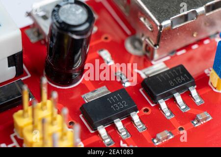 Macro shot di circuito stampato con microchip resistori e componenti elettronici. Processore di comunicazione integrato. Ingegneria delle informazioni. Foto Stock