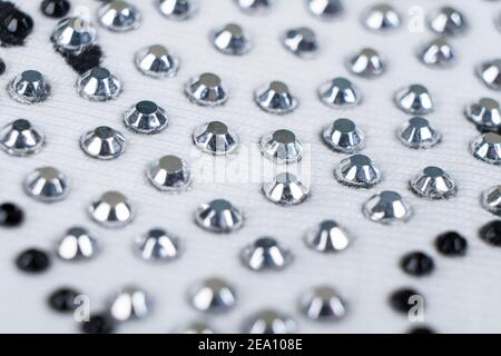 Tessuto lavorato a maglia bianco con molti motivi di strass. Tessuto di moda di fondo texture Foto Stock