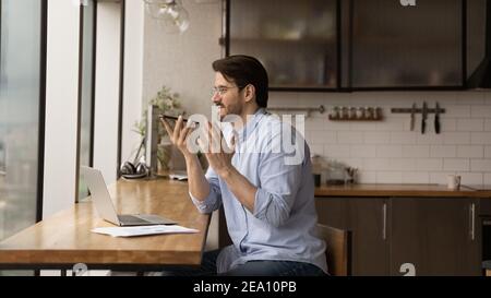 Giovane freelance uomo chiedere smartphone ai per cercare informazioni online Foto Stock