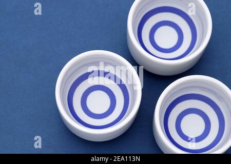 Sake giapponese in tradizionale tazza di ocoko ceramica su tavolo di legno Foto Stock