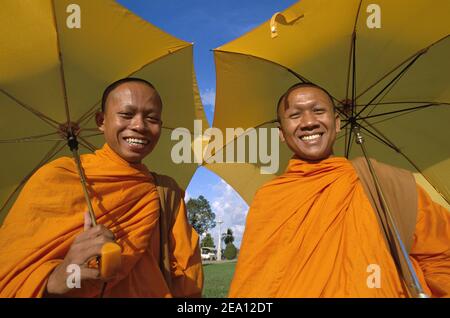 Asia, Cambogia, Phnom Penh, ritratto di due monaci buddisti camdodiani che tengono ombrelloni e sorridono Foto Stock