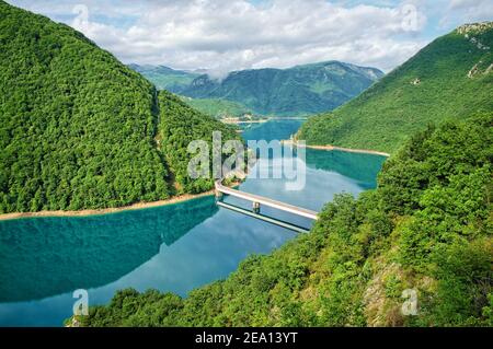 ponte sulle acque turchesi del lago Piva vicino a Pluzine, Montenegro Foto Stock