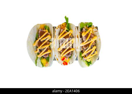 Tacos di tonno Ahi in crosta di sesamo con verdure in un morbido farina tortilla su fondo bianco Foto Stock