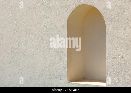 Nicchia ad arco in un muro di argilla in un giorno luminoso di sole. La struttura della parete Foto Stock