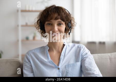 Ritratto di donna in cuffia parla in videochiamata Foto Stock