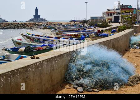 Kanyakumari, Tamil Nadu, India - Gennaio 2017: Barche di pescatori in un piccolo porto. Mucchio di attrezzatura per la rete da pesca sulla spiaggia. Messa a fuoco selettiva Foto Stock