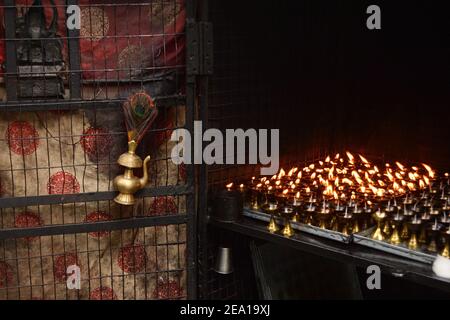Lampada a olio tradizionale indiana e candele fiammeggianti nel tempio Mahakal sulla collina Observatory, Darjeeling, India Foto Stock
