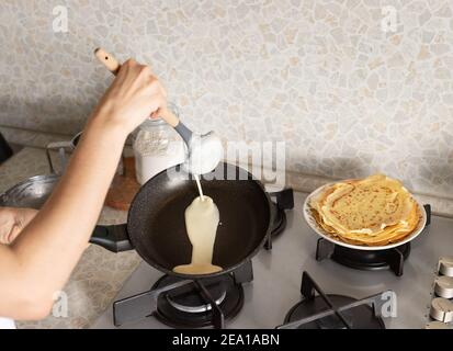 La pentola per le mani con pancake, cucinando a casa Foto stock - Alamy