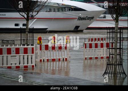 Colonia, Germania. 07 febbraio 2021. La passeggiata lungo il fiume di fronte alla città vecchia è inondata dalle acque alte del Reno. La Federal Waterways and Shipping Administration ha corretto le sue aspettative in modo significativo verso il basso. Il livello del Reno a Colonia dovrebbe ora raggiungere il picco di domenica pomeriggio a poco meno di 8.70 metri, dopo di che scenderà notevolmente. Credit: Henning Kaiser/dpa/Alamy Live News Foto Stock