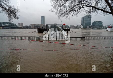 Colonia, Germania. 07 febbraio 2021. La passeggiata lungo il fiume di fronte alla città vecchia è inondata dalle acque alte del Reno. La Federal Waterways and Shipping Administration ha corretto le sue aspettative in modo significativo verso il basso. Il livello del Reno a Colonia dovrebbe ora raggiungere il picco di domenica pomeriggio a poco meno di 8.70 metri, dopo di che scenderà notevolmente. Credit: Henning Kaiser/dpa/Alamy Live News Foto Stock