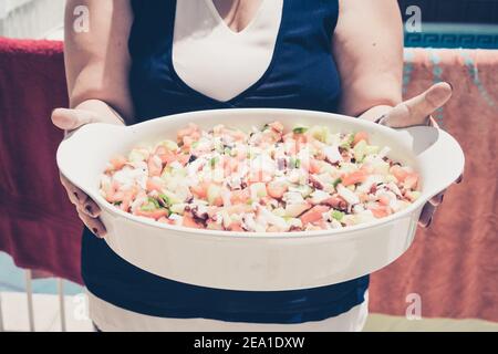 Un primo piano di una femmina che tiene ciotola piena di sano insalata di verdure Foto Stock