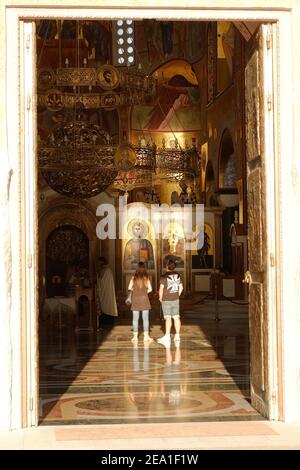 PODGORICA, MONTENEGRO - AGOSTO 17: Una coppia all'interno della Cattedrale della Risurrezione di Podgorica guardando le icone di Gesù Cristo. Girato nel 2014 Foto Stock