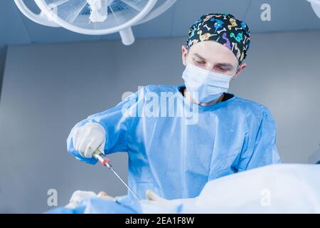 Liposuzione della chirurgia del mento. Pompando fuori il grasso nella zona del mento di una donna. Correzione della forma della faccia. Procedure di cosmetologia per persone anziane Foto Stock