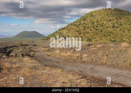 Il sentiero attraversa la 'ciara' e i vecchi coni vulcanici nel Parco Nazionale dell'Etna sud-occidentale, in Sicilia Foto Stock