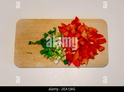 Cipolla tagliata e peperone rosso su tavola di legno Foto Stock