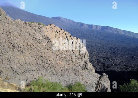 Parete rocciosa e flusso lavico raffreddato nella Valle Bove del Parco Etna, Sicilia Foto Stock