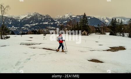 Escursione con le racchette da neve sul Walgau nel Vorarlberg innevato. Schneeschuhwanderung im Hochmoor über Sateins mit Saharasand am Himmel. Stadel Foto Stock