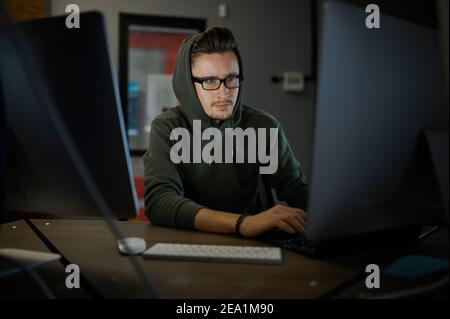 Uomo internet hacker in cappuccio e occhiali Foto Stock