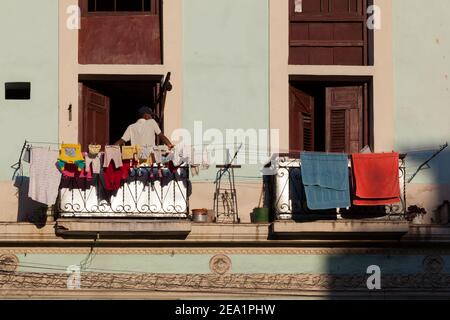 L'Avana, Cuba - MARZO 06, 2013: Cuban sul balcone di un vecchio stile Spagnolo a casa. Lavanderia Baby è appeso sul balcone Foto Stock