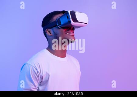 Tecnologie moderne per l'intrattenimento. Uomo nero eccitato che indossa occhiali vr guardando da parte Foto Stock