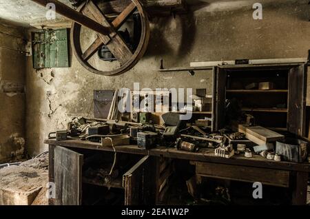 vecchio banco di lavoro nella cantina di fabbrica abbandonata Foto Stock