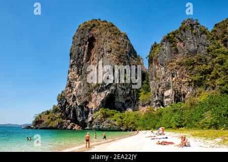 Una gigantesca formazione rocciosa si affaccia sulla sabbia bianca e sul mare blu di Railay Beach, a Krabi, Thailandia Foto Stock