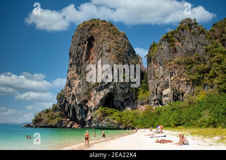 Una gigantesca formazione rocciosa si affaccia sulla sabbia bianca e sul mare blu di Railay Beach, a Krabi, Thailandia Foto Stock