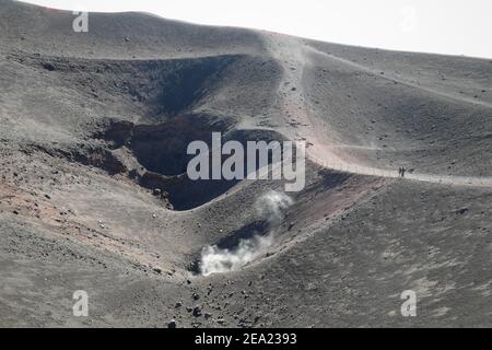 PARCO NAZIONALE DELL'ETNA, SICILIA, ITALIA - 18 OTTOBRE 2014: I turisti guardano ad alcuni dei tanti crateri sommitali dai quali esce un po' di fumo Foto Stock