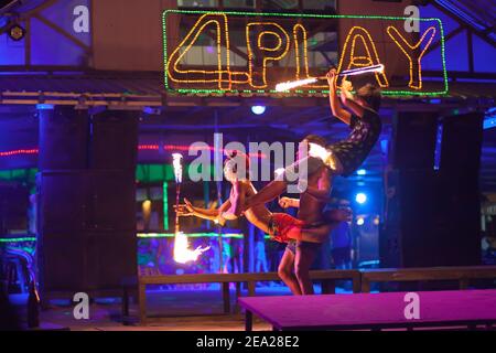 Fireshow in Thailandia. Un gruppo di ragazzi giovani esegue un acrobatico acrobatico stunt con torce. Isola di Phi phi Foto Stock