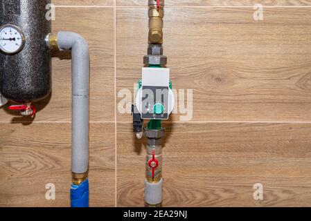 Pompa di circolazione dell'acqua per il riscaldamento a pavimento in un moderno locale caldaia a gas rivestito di piastrelle in ceramica. Foto Stock