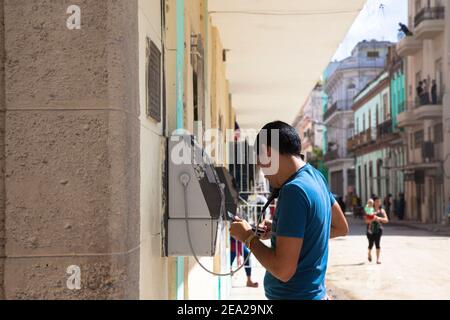 L'AVANA, CUBA: Il giovane chiama usando un telefono pubblico (telefono a pagamento) su una strada dell'Avana Foto Stock