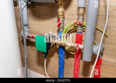 Pompa di circolazione dell'acqua per il riscaldamento a pavimento in un moderno locale caldaia a gas rivestito di piastrelle in ceramica. Foto Stock