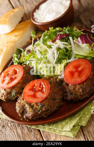 Closeup pakistano Chapli Kebab nella padella sul tavolo. Verticale Foto Stock