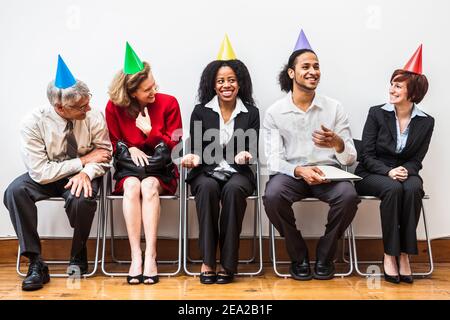 Un gruppo di uomini d'affari che indossano cappelli da festa. Foto Stock