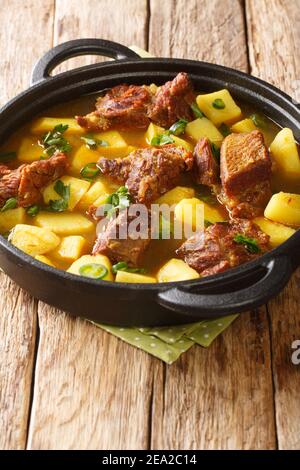 Gustosa ricetta Aloo Gosht Mutton Curry con chioccia di patate nella padella sul tavolo. Verticale Foto Stock