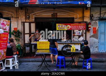 Due donne cucinano cibo di strada dal loro chiosco di cibo a Chinatown, Bangkok, Thailandia Foto Stock