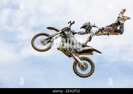 Pilota di motocross che salta di fronte al cielo nuvoloso, Biberach, Baden-Wuerttemberg, Germania Foto Stock