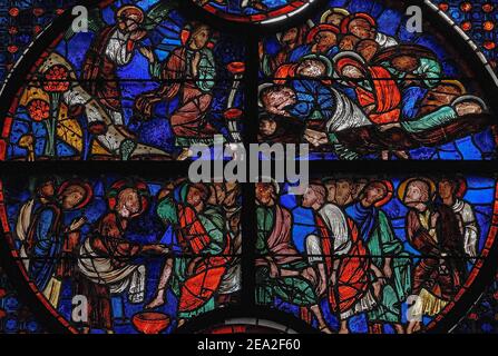 L'agonia a Getsemani (in alto) e Gesù lavando i piedi dei suoi discepoli nell'ultima cena: Due scene della settimana Santa Passione di Cristo raffigurato in un roundel di vivide vetrate del 13th ° secolo nella finestra lancetta centrale che piercing la parete del coro orientale del medievale gotico Cathédrale Notre-Dame de Laon a Laon, Aisne, Hauts-de-France, Francia. La scena superiore mostra gli apostoli stanchi che dormono nel Giardino del Getsemani, nonostante promettano che Gesù avrebbe vegliato e pregato mentre sopportava l'angoscia di sapere che sarebbe stato tradito, arrestato e crocifisso. Foto Stock