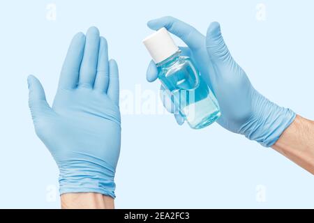 La mano isolata con guanti utilizza un disinfettante liquido a base di alcol che uccide la maggior parte dei tipi di microbi e virus. Concetto di Covid e germofobia Foto Stock
