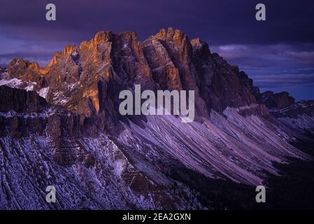 Le pareti rocciose innevate e le scogliere delle vette Geisler dei monti Puez-Odle illuminano all'alba, Dolomiti, Alto Adige, Italia Foto Stock